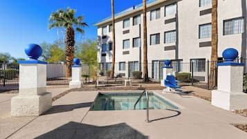 Ein Hotel mit Schwimmbad, Palmen und einer modernen Fassade.