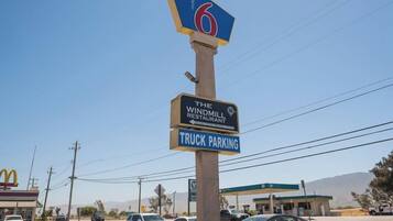 A motel sign with a windmill restaurant and a truck parking sign.