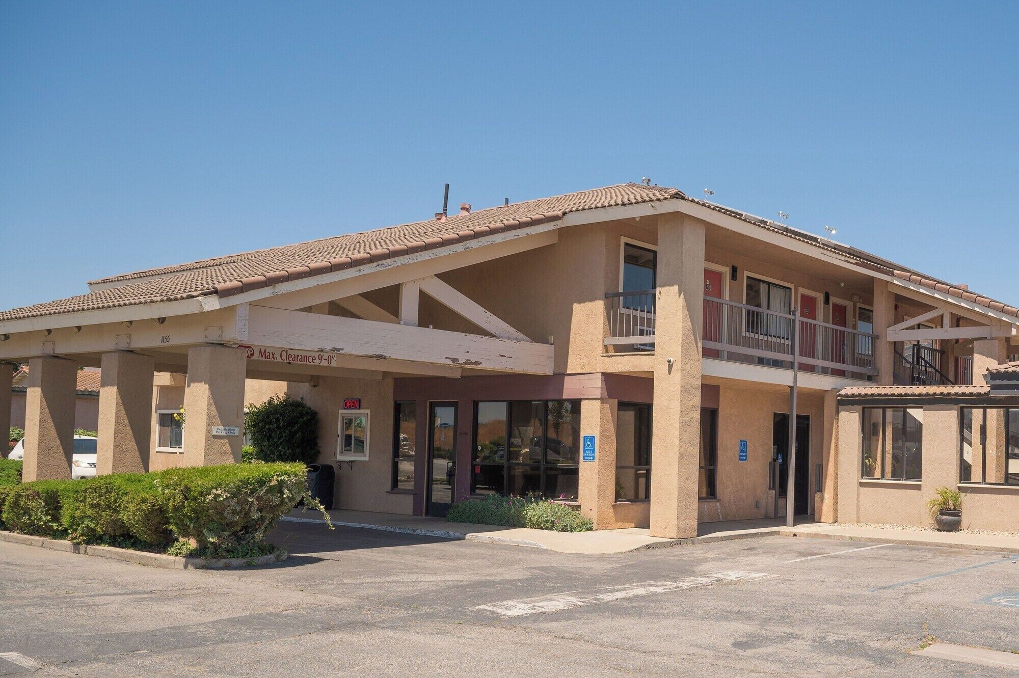 A two-story building with a covered entrance and a balcony.