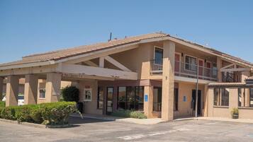 A two-story building with a covered entrance and a balcony.