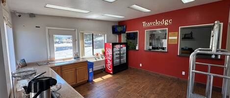 A kitchen area with a countertop, a refrigerator, and a Coca-Cola cooler.