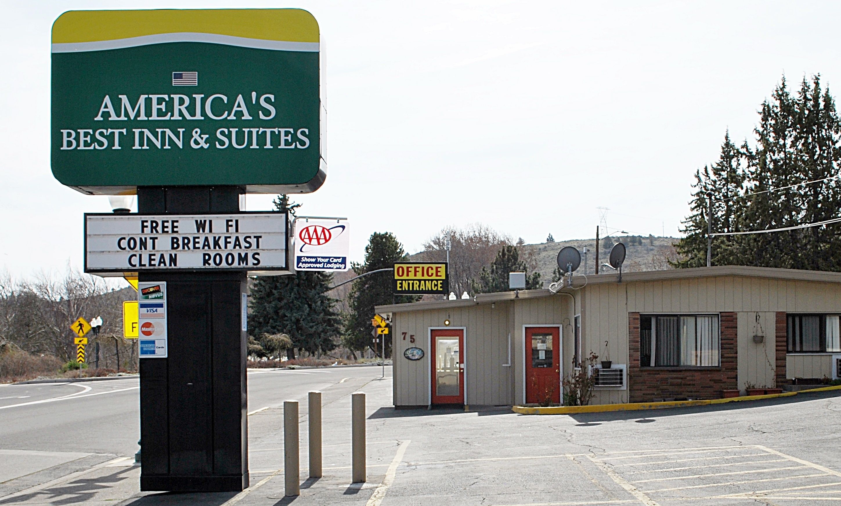 A sign for America's Best Inn & Suites with amenities like free WiFi, breakfast, and clean rooms.