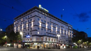 Un hotel de varios pisos con un letrero llamativo de 'Plaza Premium', varias tiendas en la planta baja y un letrero visible de 'Loft'.