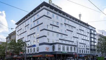 Un hôtel à plusieurs étages au design moderne, doté de balcons et de grandes fenêtres.