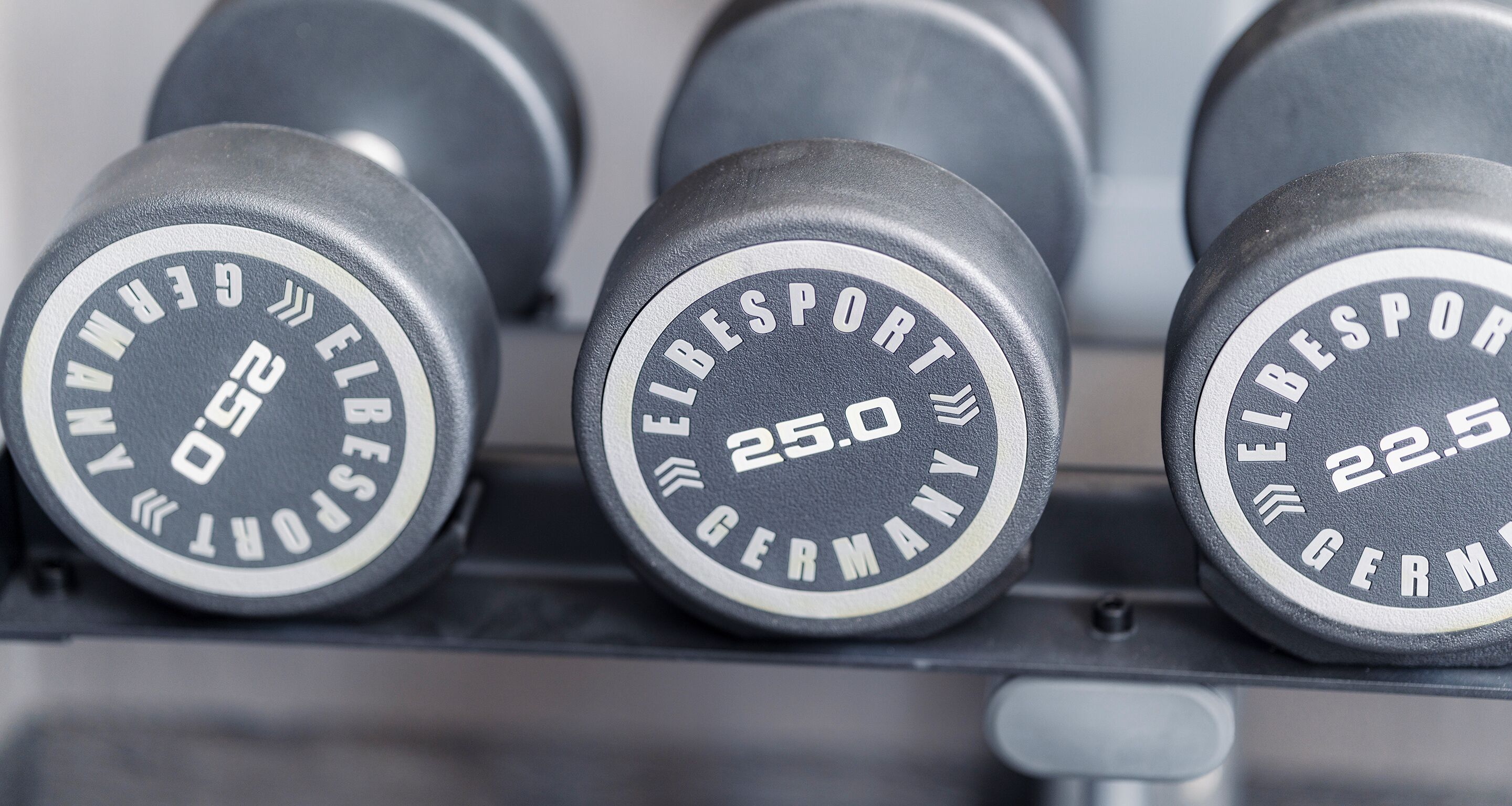 A set of weightlifting dumbbells labeled with weights and brand name.