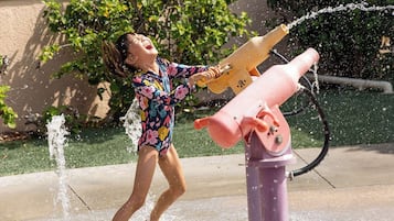 Niño jugando con una fuente de agua.