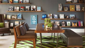 A modern living room with a sofa, a coffee table, and a bookshelf filled with books and decorative items.