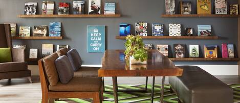A modern living room with a sofa, a coffee table, and a bookshelf filled with books and decorative items.