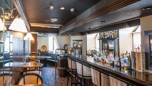 A bar area with wooden furniture, a bar counter, and a variety of bottles. - Hotel Strix Tokyo (Tokyo)