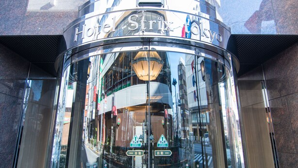 A modern hotel entrance with a glass facade and a sign reading "Hotel Strix Tokyo". - Hotel Strix Tokyo (Tokyo)
