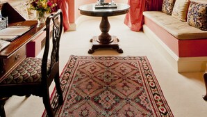 A room with a large window, a round table with a vase, a sofa, and a chair. - Hartwell House & Spa (Aylesbury)