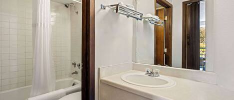 A bathroom with a bathtub, toilet, and sink.