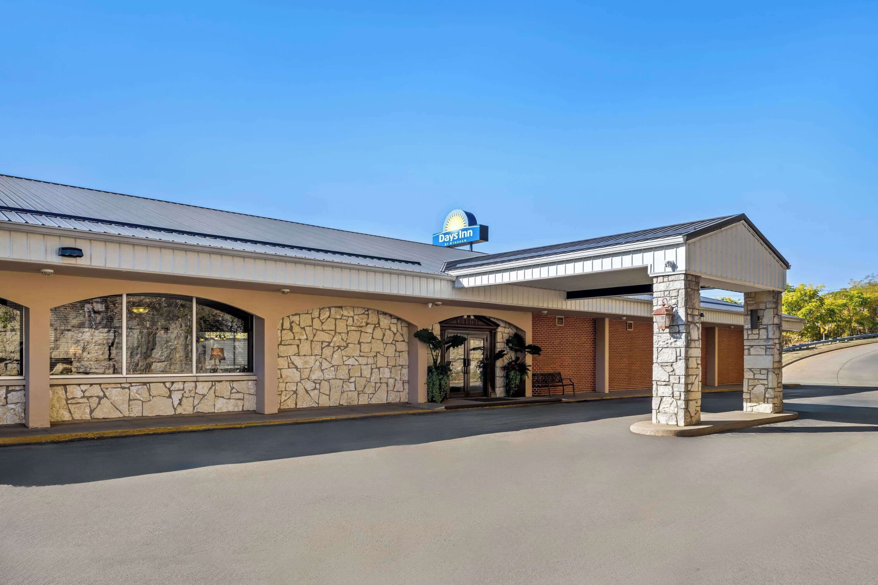 A Days Inn with a stone facade, large windows, and a covered entrance.