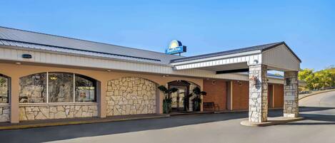 A Days Inn with a stone facade, large windows, and a covered entrance.