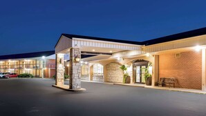 A hotel with a covered entrance, stone pillars, and a brick facade.