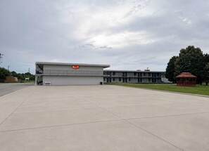 A large building with a flat roof and a red circular logo on the side.
