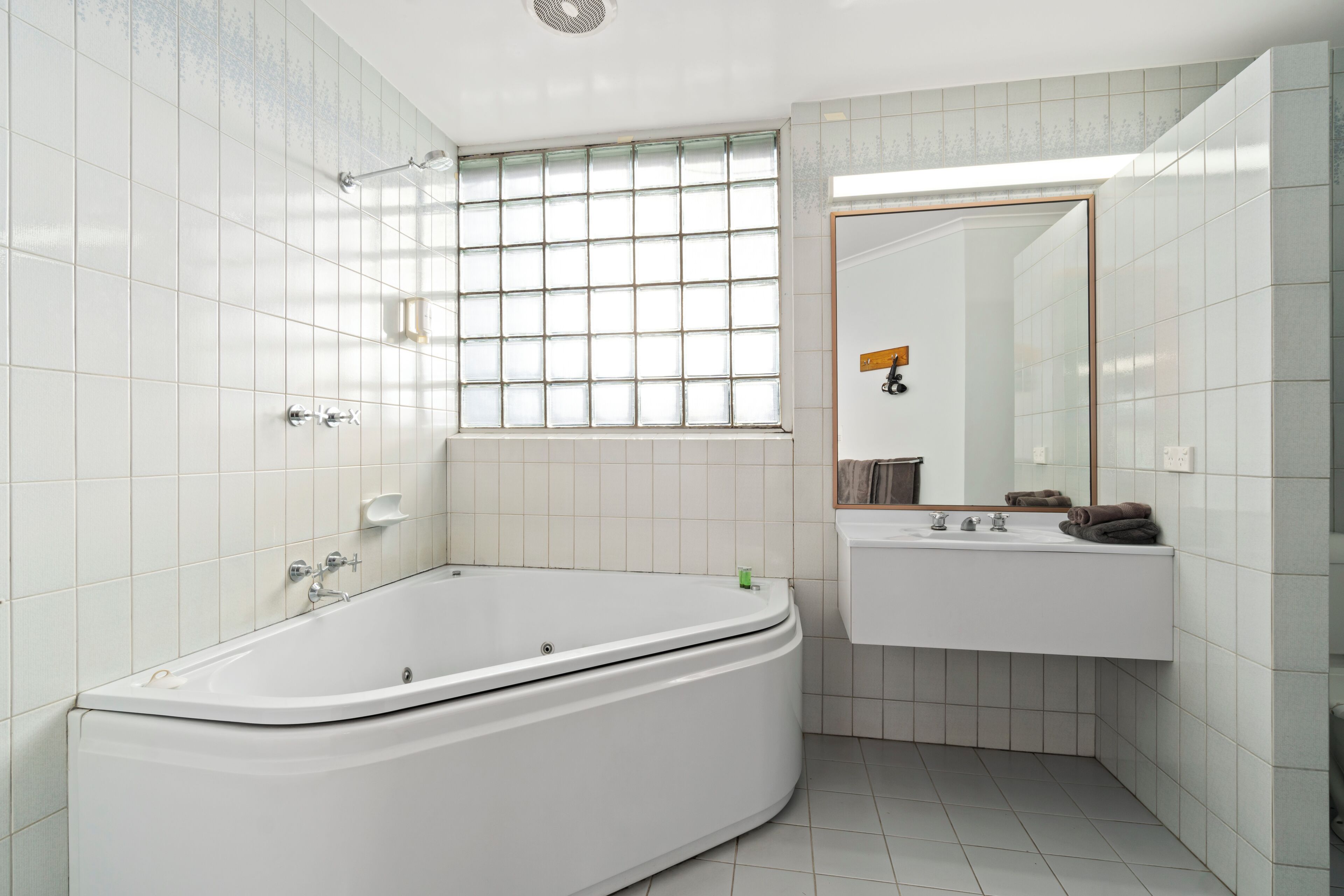 Un baño moderno con una bañera independiente, un tocador con espejo y una ventana con vistas.