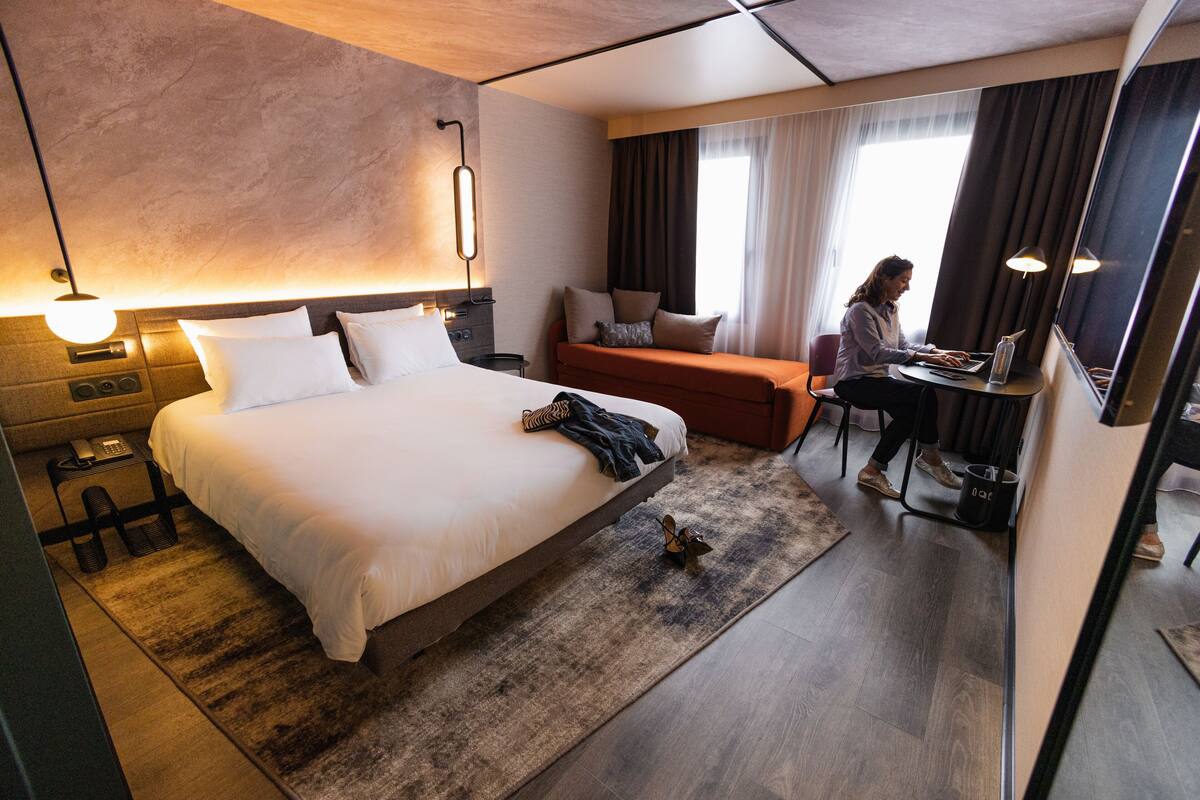 Ein modernes Hotelzimmer mit einem großen Bett, einem Schreibtisch und einer Sitzecke.