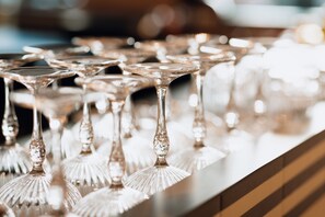 A row of clear, stemmed glassware on a reflective surface. - Novotel Paris Suresnes Longchamp (Suresnes)