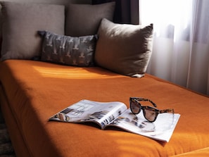 Un lit avec un magazine et des lunettes de soleil dessus.