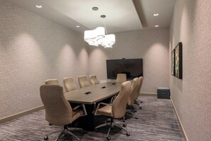 A conference room with a long table, six chairs, a flat-screen TV, and a patterned carpet. - Hyatt House Portland Airport (Portland)
