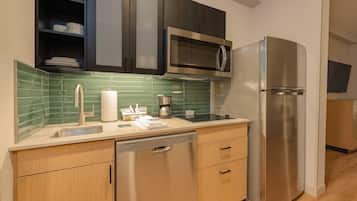 A modern kitchen with a stainless steel refrigerator, a microwave, and a dishwasher.
