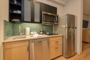 A modern kitchen with a stainless steel refrigerator, a microwave, and a dishwasher. - Hyatt House Portland Airport (Portland)