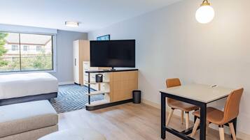 Una sala moderna con sofá, reposapiés, mesa de comedor y sillas.