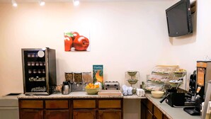 A kitchen area with a refrigerator, coffee machine, and various food items on the counter. - Quality Inn near Manatee Springs State Park (Chiefland)