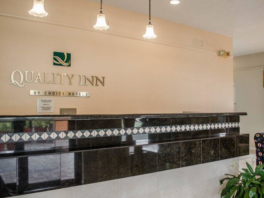 A reception desk with a sign reading "Quality Inn by Choice Hotels."