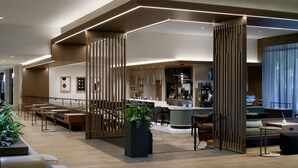 A modern hotel lobby with a bar area, seating, and a reception desk. - Sheraton Park Hotel at the Anaheim Resort (Anaheim)