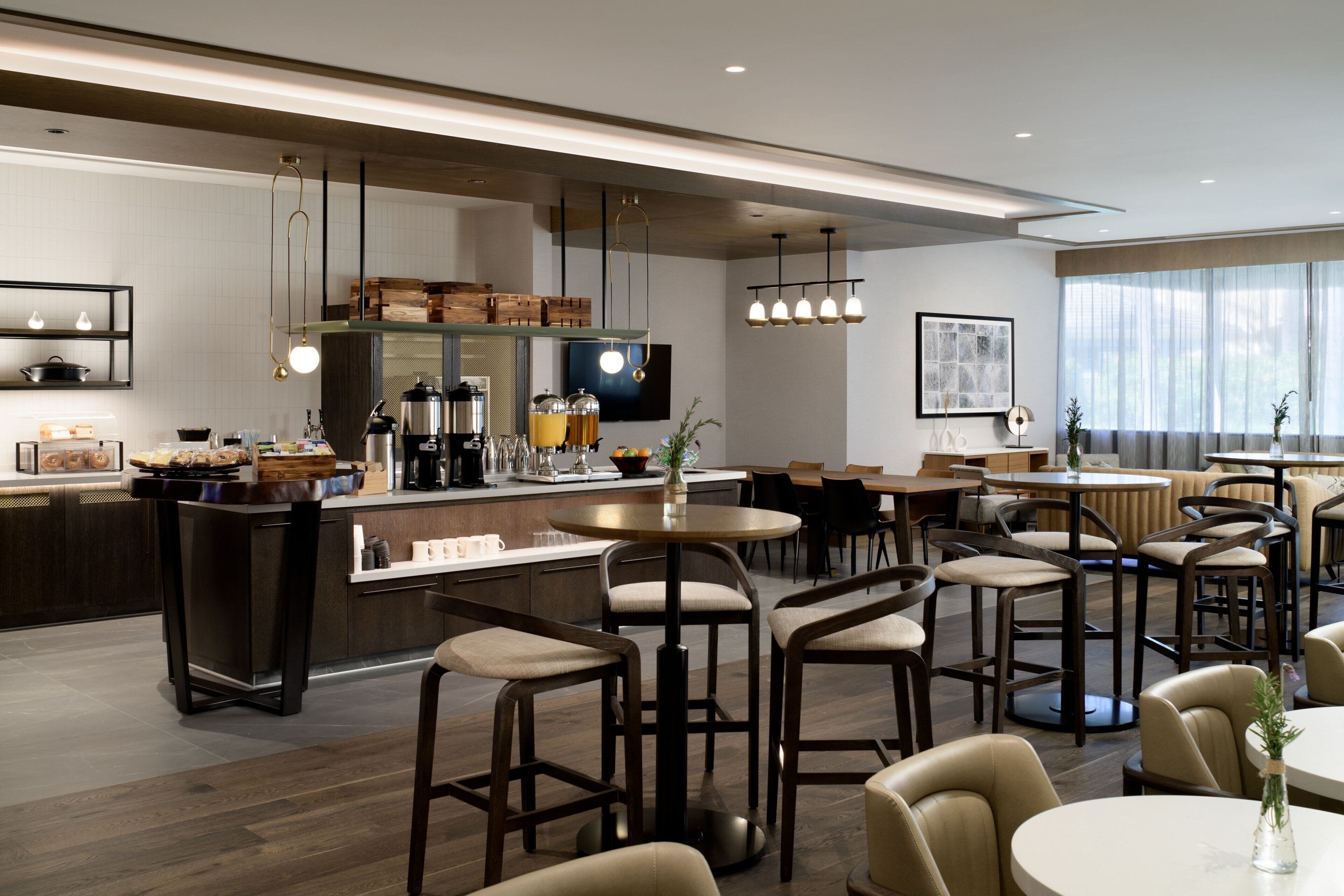 A modern kitchen with a central island, bar stools, and pendant lighting.