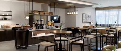 A modern kitchen with a central island, bar stools, and pendant lighting.