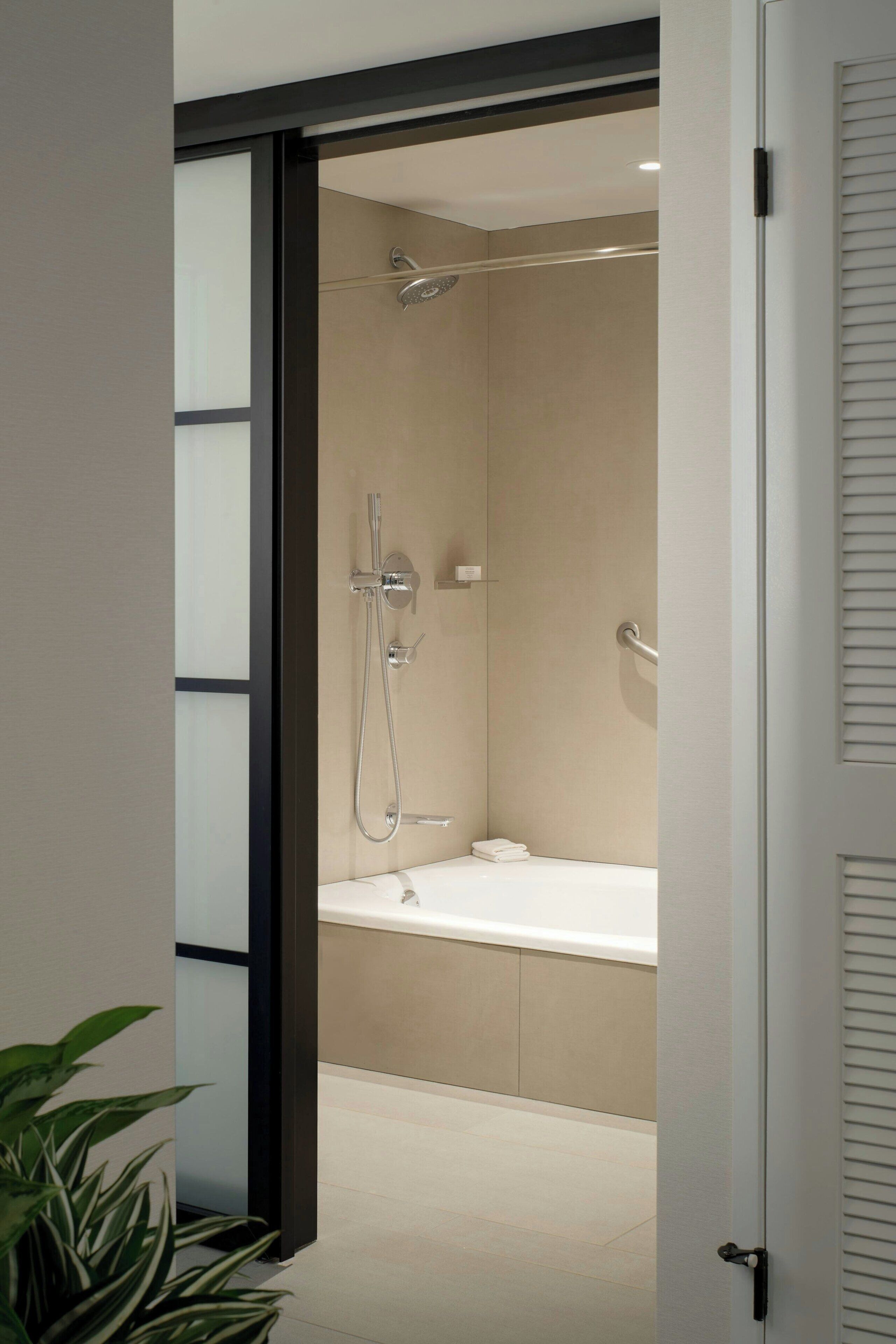 A modern bathroom with a shower, a bathtub, and a toilet.