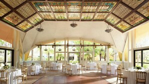 A spacious room with large windows, a high ceiling with stained glass, and tables set for dining. - Sheraton Park Hotel at the Anaheim Resort (Anaheim)