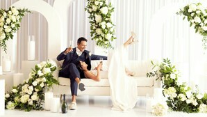 A man and woman sitting on a white sofa in a room with white walls and arches. - Sheraton Park Hotel at the Anaheim Resort (Anaheim)