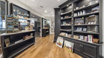 A modern interior with wooden flooring, dark shelving units, and various items displayed on shelves.