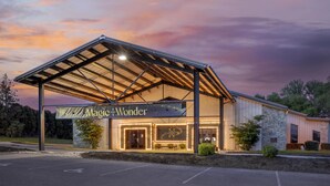 Een gebouw met een bord waarop 'Magic and Wonder' staat, met een overdekte ingang, een stenen gevel en een ster-logo.