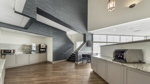 Een moderne keuken met een visgraatvloer, een ingebouwde grill en een trap naar een hoger gelegen verdieping.