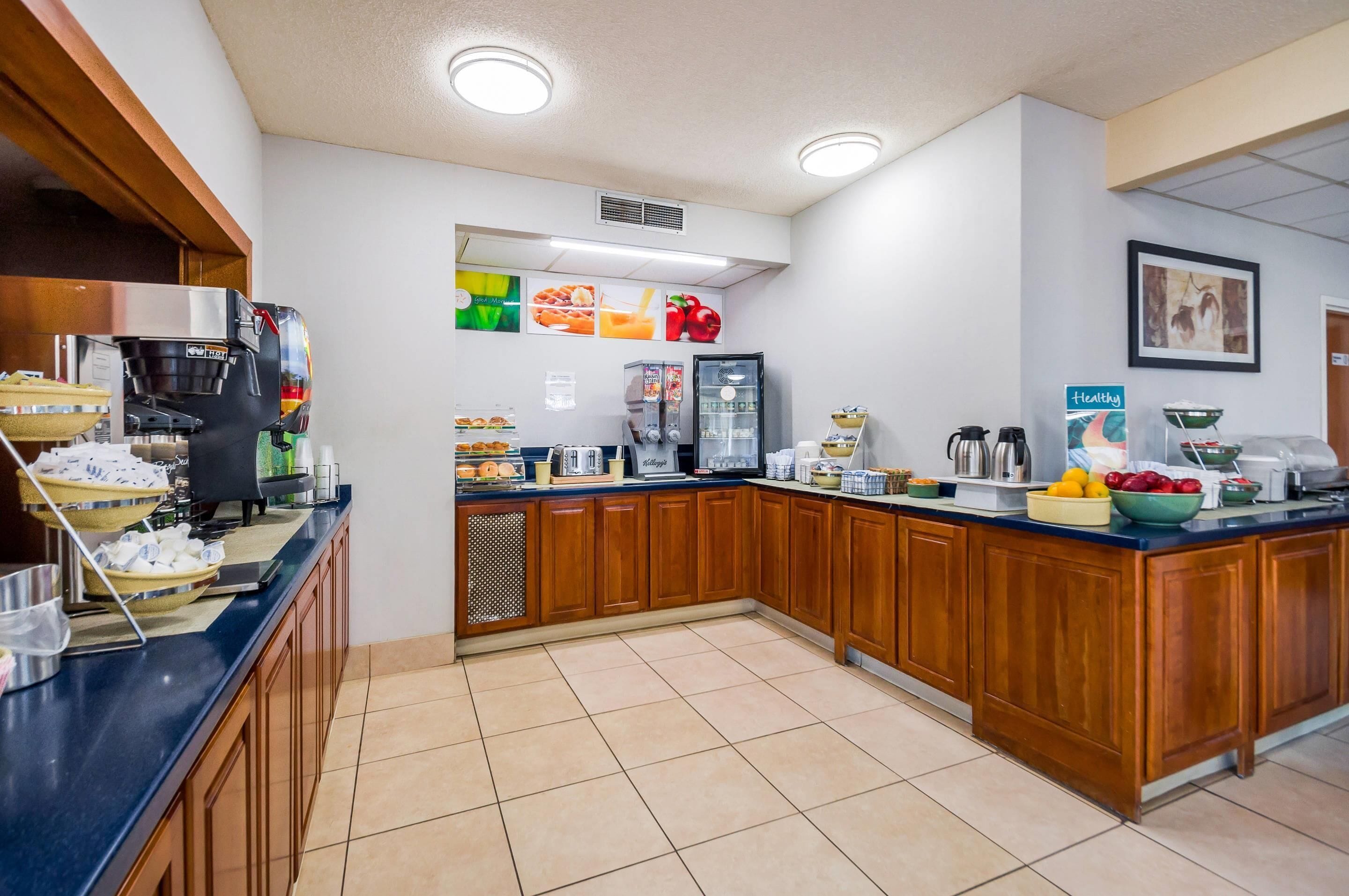 A modern kitchen with a coffee machine, refrigerator, and various food items on the counter.