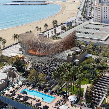 A hotel with a pool, a beach, and a Ferris wheel.