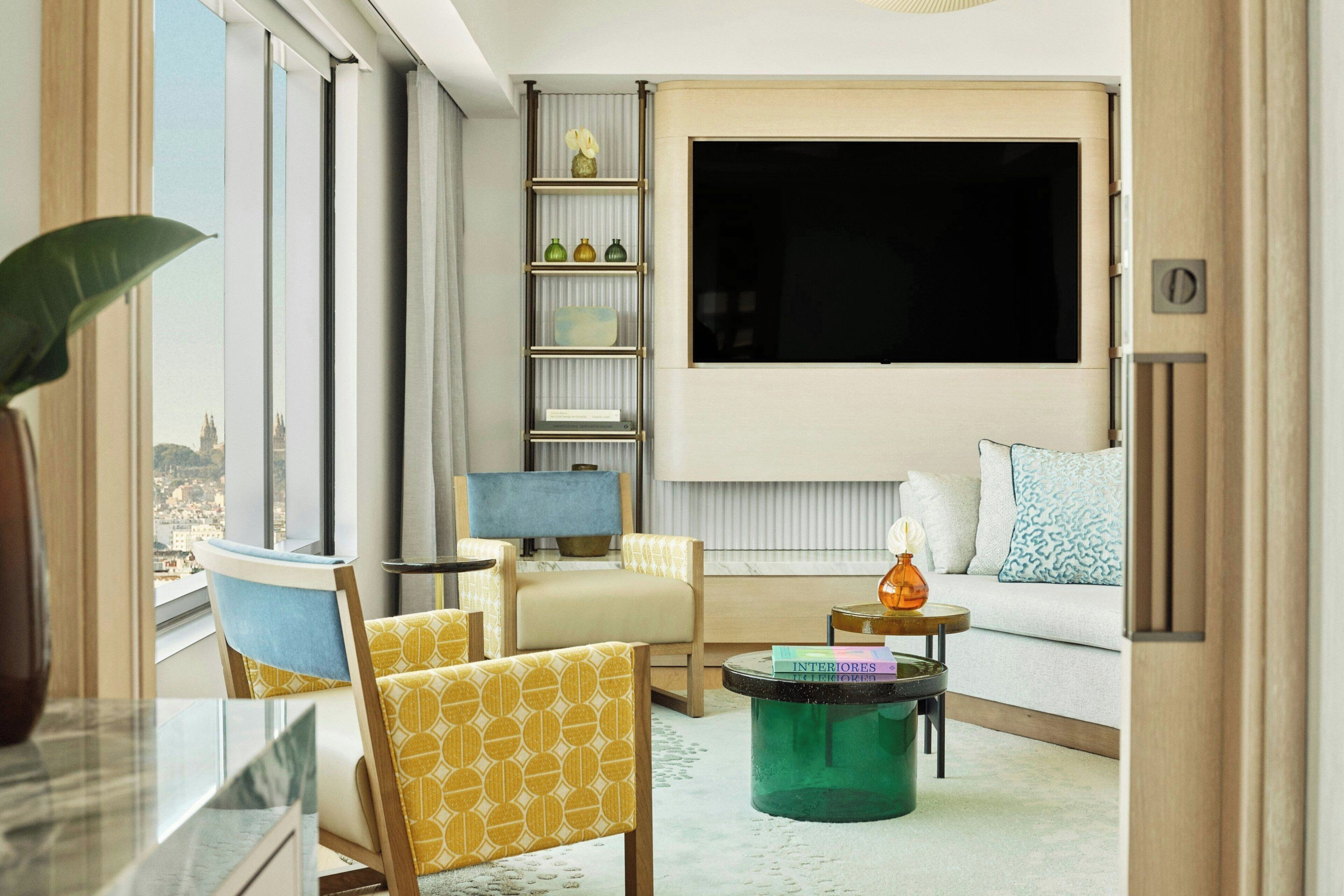 En moderne stue med sofa, stole, sofabord og fjernsyn.