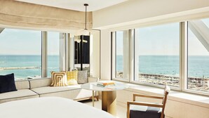 A modern hotel room with a large bed, a round table, and a view of the sea. - Hotel Arts Barcelona (Barcelona)