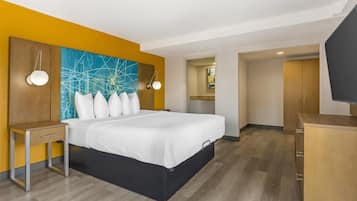 A hotel room with a bed, bedside table, and a TV.