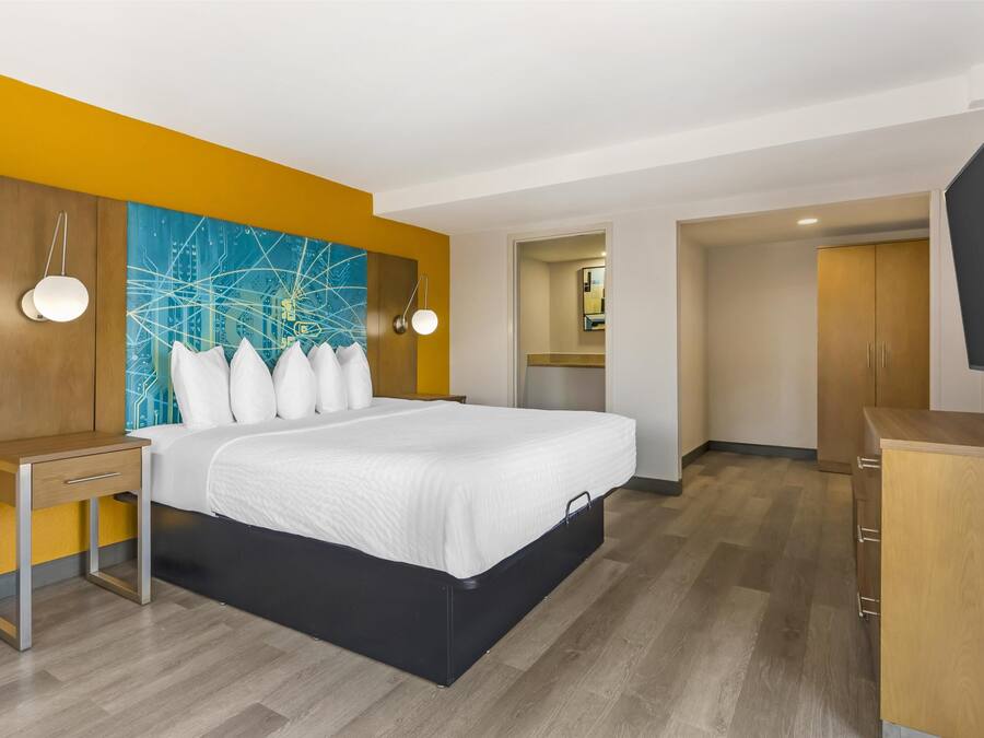 Een hotelkamer met een bed, nachtkastje en een televisie.