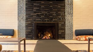 A fireplace with a modern design, flanked by patterned walls and cushioned seating. - Radisson Hotel and Conference Center Fond du Lac (Fond du Lac)