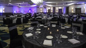 A banquet hall with round tables set for dining, featuring black tablecloths and silver sashes. - DoubleTree by Hilton Hotel Wilmington (Wilmington)