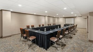 A conference room with a long table, chairs, and a projector screen. - DoubleTree by Hilton Hotel Wilmington (Wilmington)