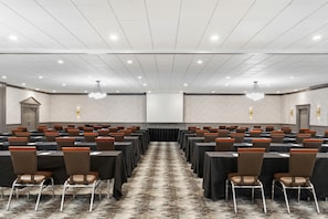 A conference room with rows of tables and chairs, a carpeted floor, and a white ceiling with recessed lighting. - DoubleTree by Hilton Hotel Wilmington (Wilmington)