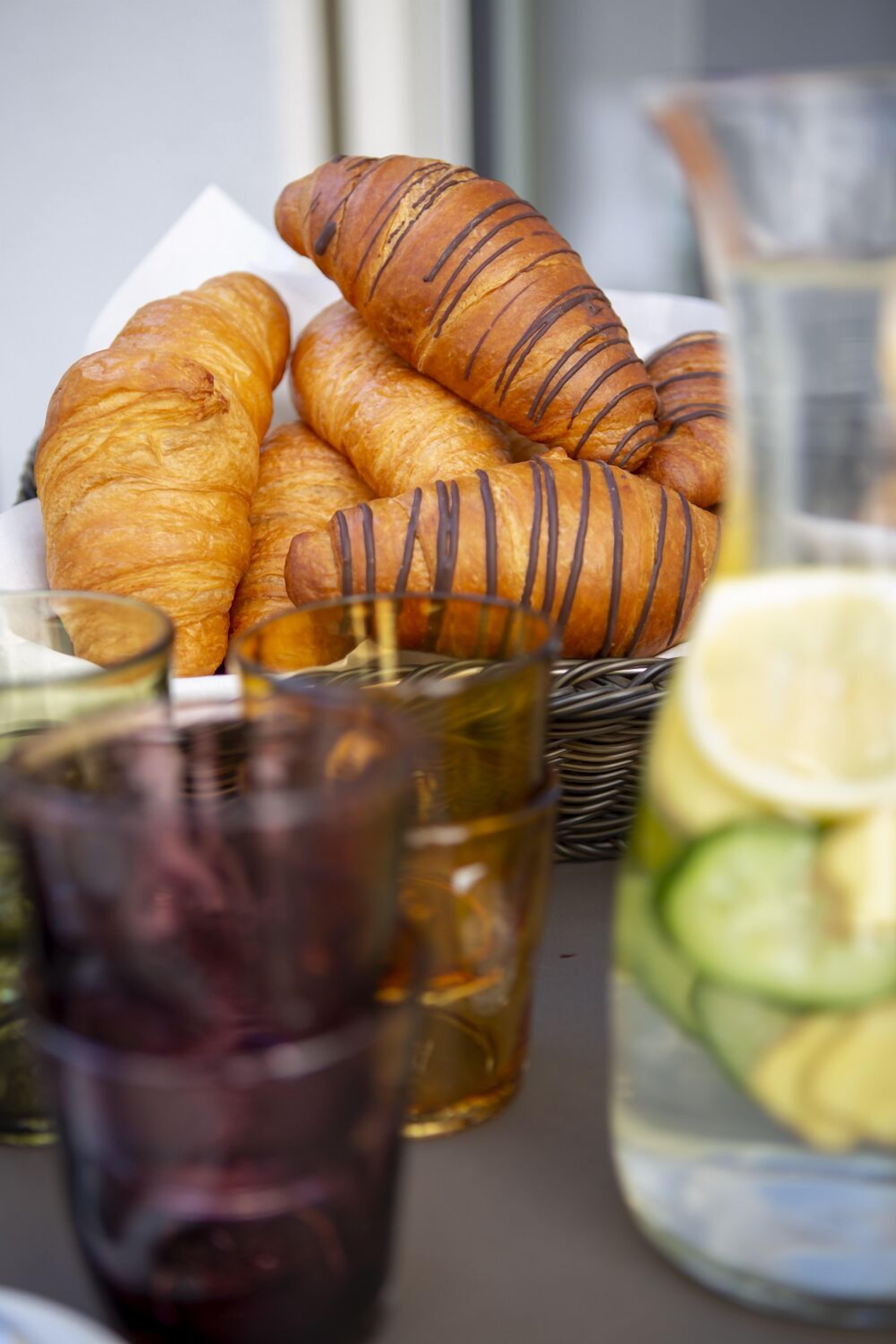 Un panier de croissants et une tasse de thé sur une table.